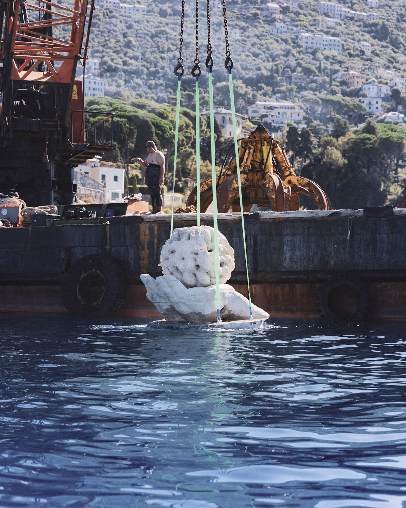 The sculpture lifted above the water before being lowered
